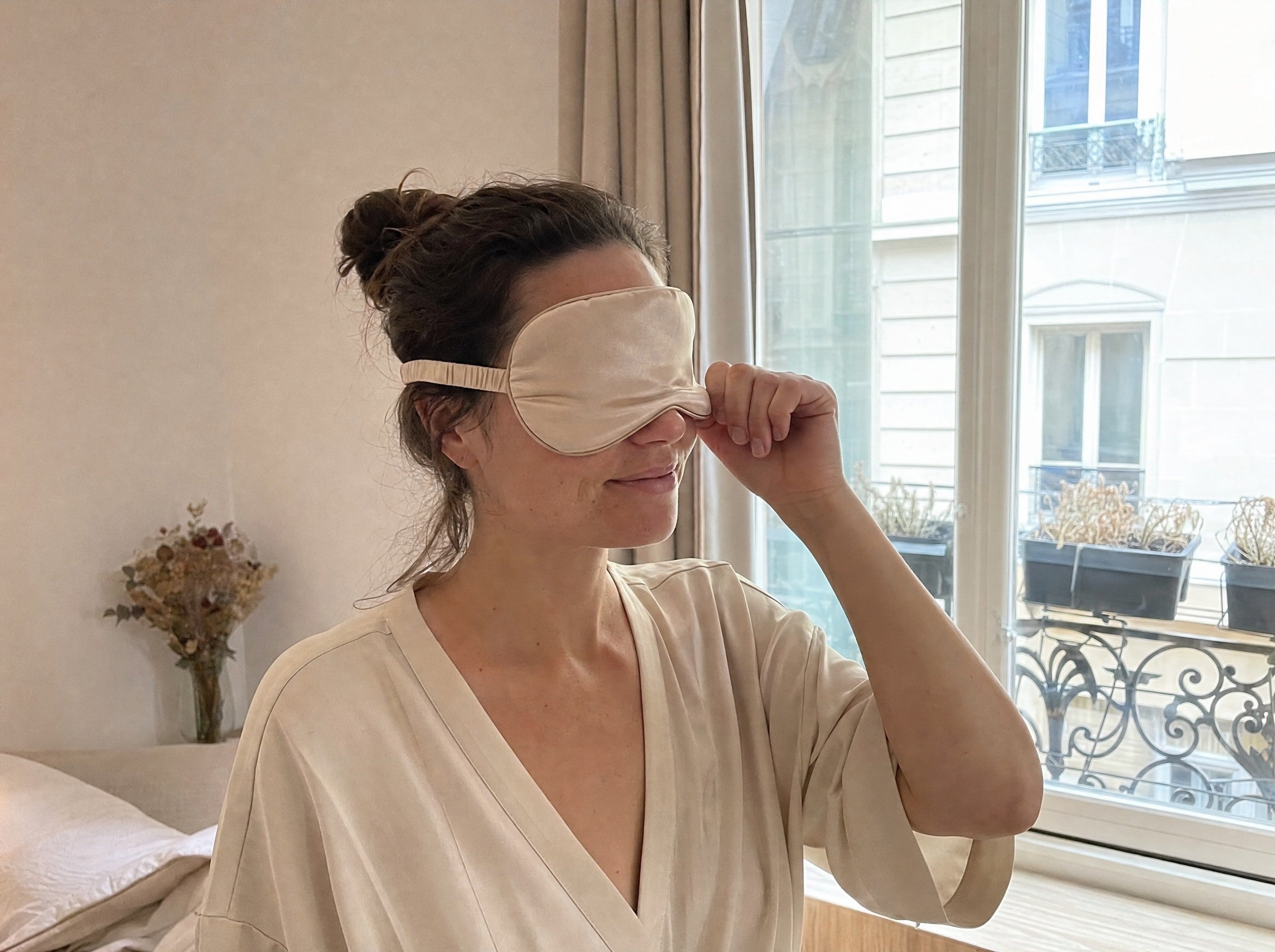 Une femme porte un masque de sommeil champagne